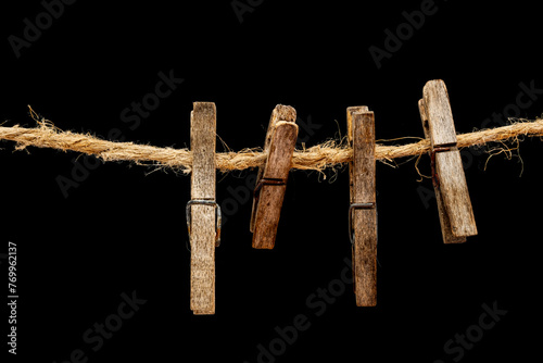 Old wooden clothespins, laundry hooks, on hemp rope, dark background