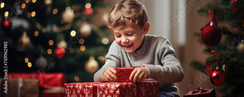 Happy cute boy is surprised in opening his christmas presents