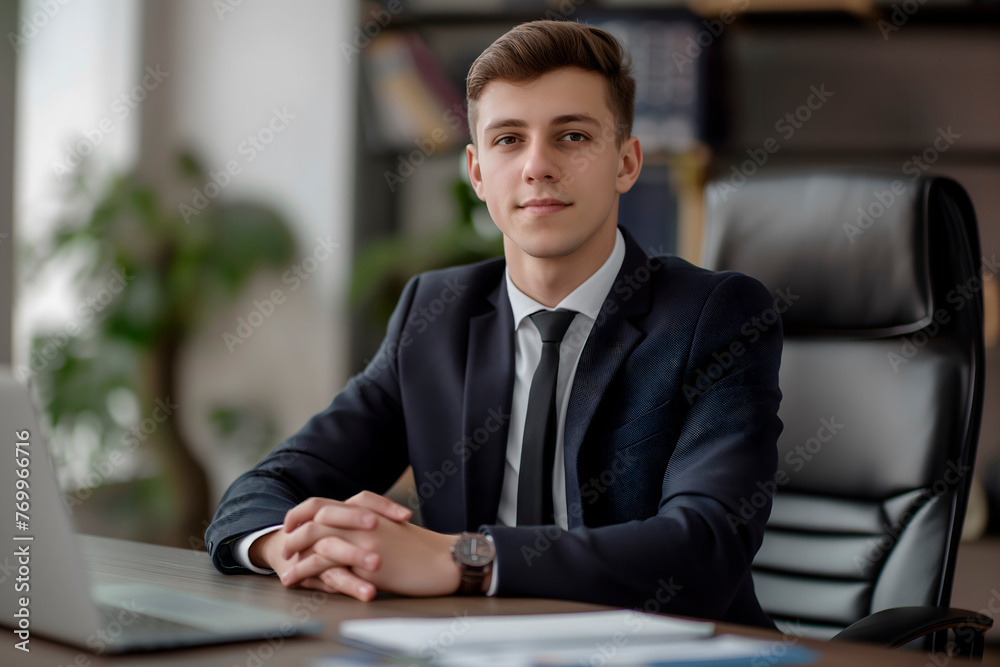 Portrait of a confident young man, businessman, executive director, boss, sitting at an office desk in a business suit and looking at the camera with his arms crossed,concept of business materials Portrait of a confident young man, businessman, executive director, boss, sitting at an office desk in a business suit and looking at the camera with his arms crossed,concept of business materials