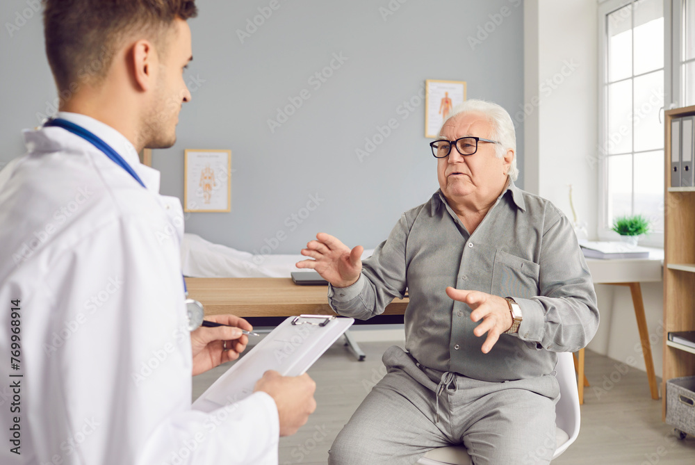 Obraz premium Senior patient man seeks medical care and attention during a hospital consultation. Engaging in a talking with the doctor and nurse, this image reflects the importance of healthcare for the elderly.