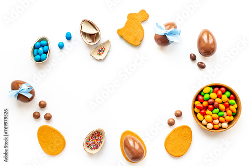 Easter festive background. Chocolate Easter eggs in blue ribbon with sweets