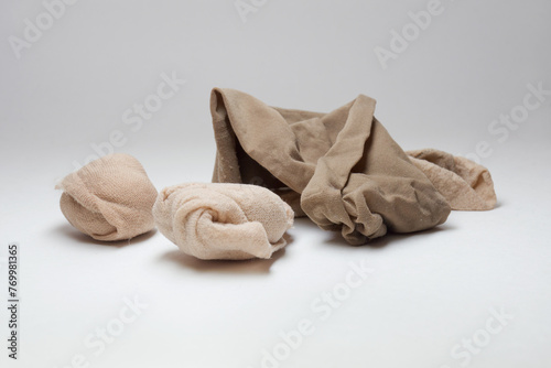 try on nylon socks for fitting shoes, disposable. beige tan, different shades, rolled up into balls. scattered
