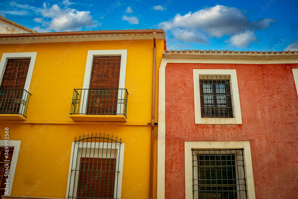 Typical red and yellow colored facades of the old town of Librilla, Region of Murcia, Spain