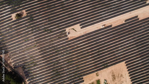 Top-down aerial perspective of symmetrical solar panel rows during the construction phase of a new solar energy plant. photo