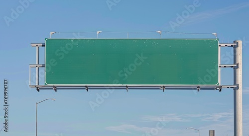 A blank highway sign with no text or graphics on it, hanging over an American three lane superhighway against the blue sky