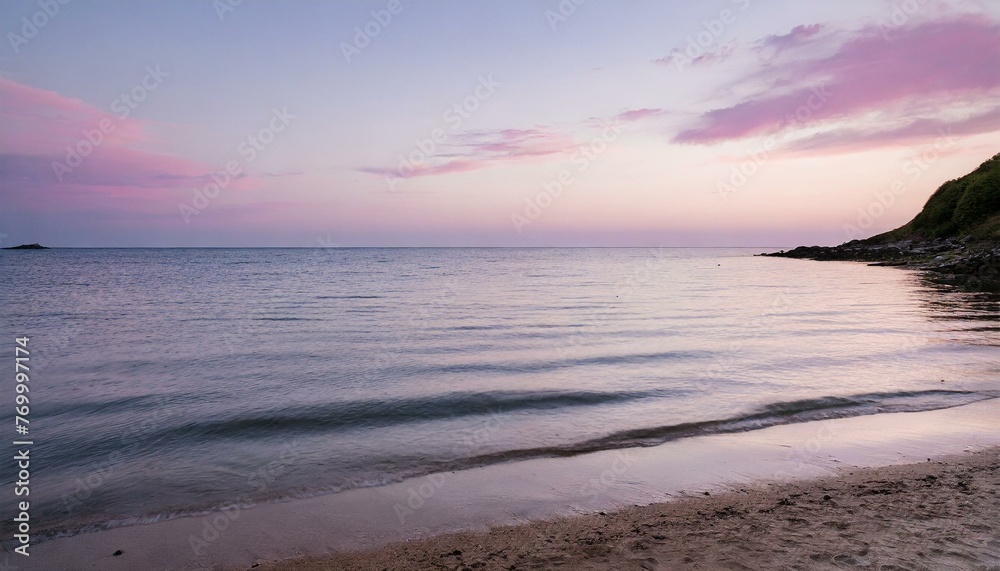 peaceful beach at dusk with pink hues on the horizon