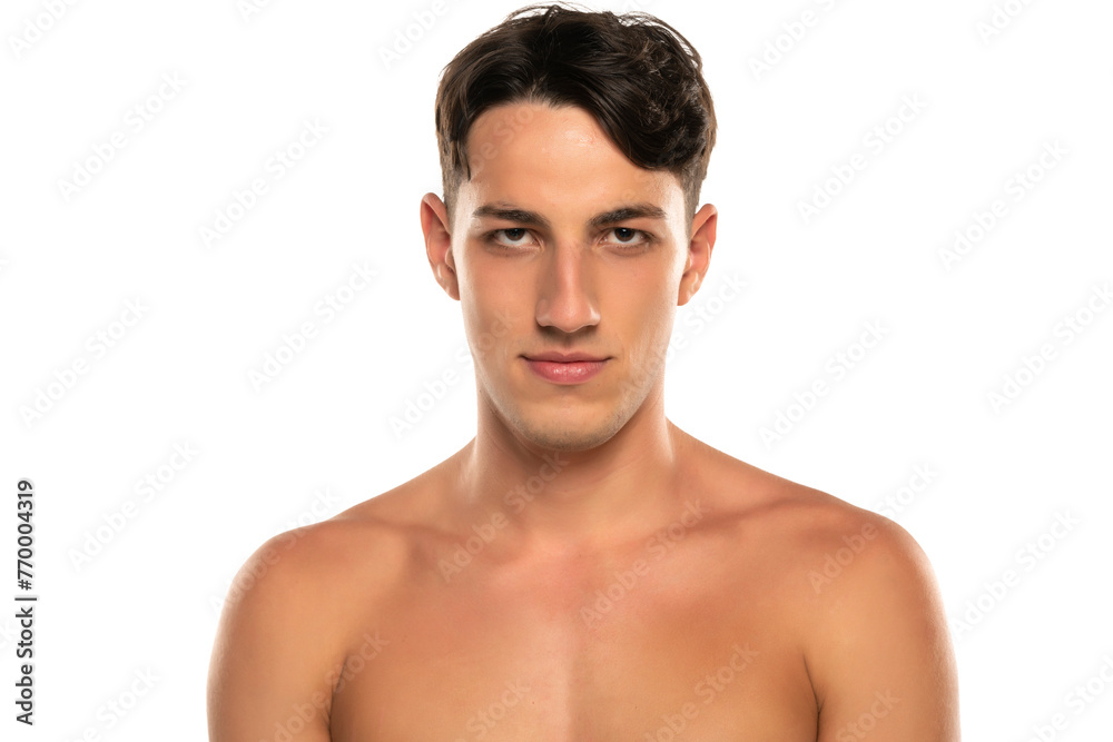Fototapeta premium Closeup portrait of smiling shirtless man 20s looking at camera isolated over white background