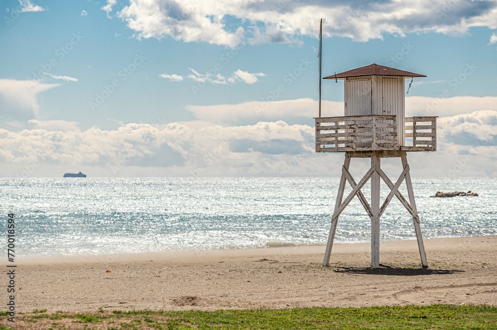 Lifeguard tower on the beach on a day with calm sea and blue sky with clouds