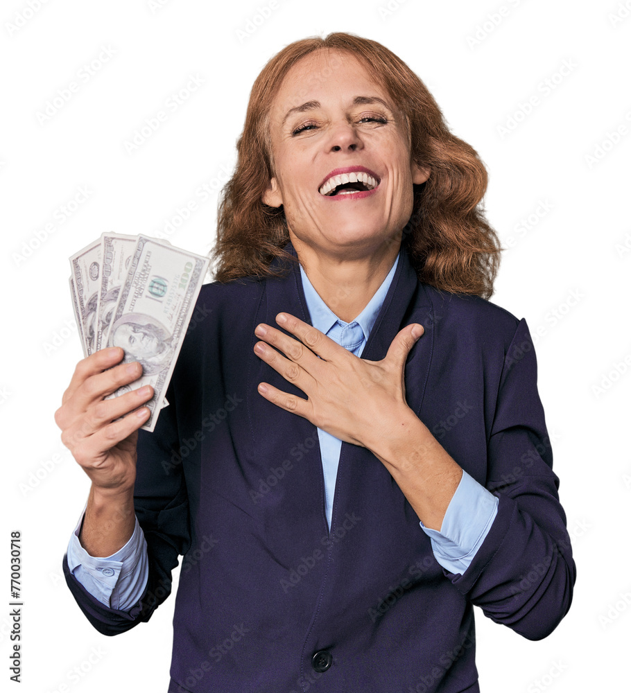 Mid-aged Caucasian with dollars in studio laughs out loudly keeping hand on chest.