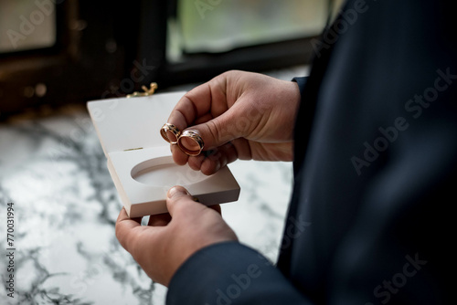 The groom holding the wedding rings 