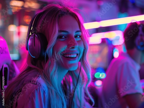 Medium shot of a female gamer laughing with friends over a neon-lit gaming setup, celebrating their collective win