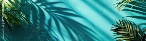 Medium shot of a palm leaf shadow falling over a solid turquoise background, creating a cool, summer feel with space for text