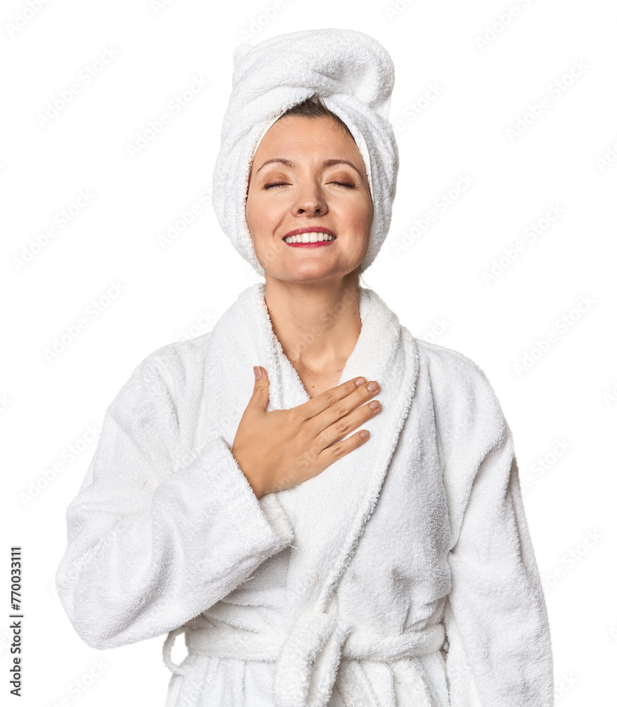 Caucasian woman in bathrobe and towel laughs out loudly keeping hand on chest. Caucasian woman in bathrobe and towel laughs out loudly keeping hand on chest.