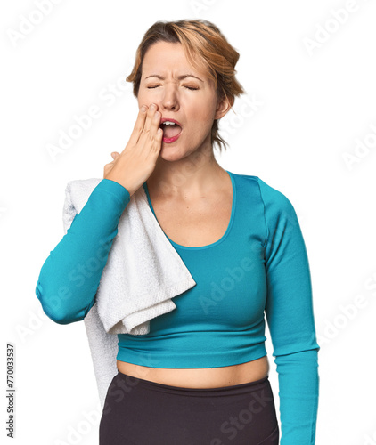 Caucasian woman in sportswear with towel yawning showing a tired gesture covering mouth with hand.