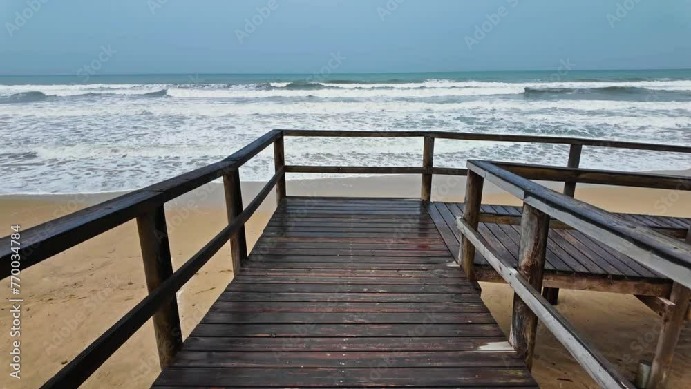 The sandy shore is washed by the frothy waves of the choppy sea. Resort background of the sandy beach The sandy shore is washed by the frothy waves of the choppy sea. Resort background of the sandy beach