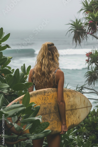 Woman Standing on Beach Holding Surfboard