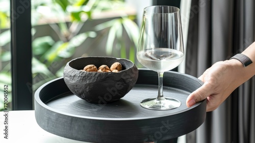  A tray holds a glass of wine and a bowl of nuts