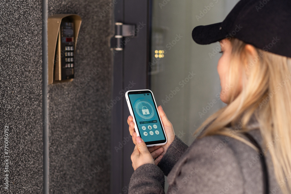 Φωτογραφία woman uses smartphone to open the door of his house