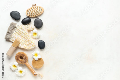 Composition with spa accessories and tropical flowers on light background