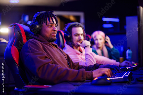 African american male cybersport gamer playing video games in a gameroom photo