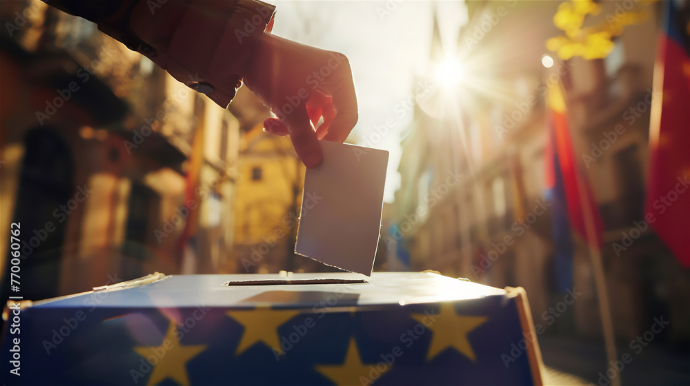 Election - voting at the ballot box. A hand putting an vote in the ballot box situated on the street.