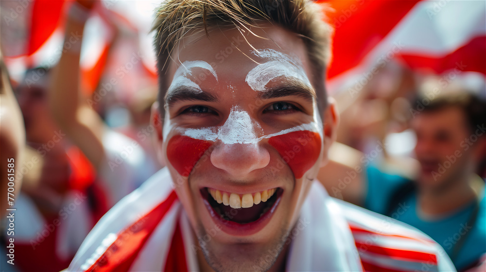 A cheerful fan of the national team with a cheering crowd in the background.