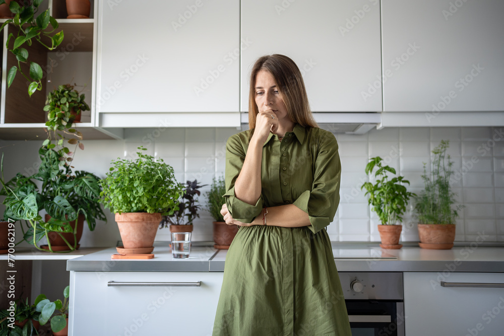 Disappointed serious worried woman pondering at home on kitchen. Upset frustrated thoughtful blonde female have problems, depression, desperation, hopelessness, frustration negative emotions in stress