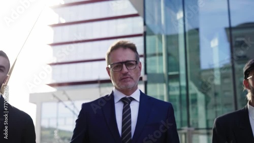 Wallpaper Mural Wide shot of four businessmen walking towards the camera with determination outside financial district. Entrepreneur people concept. Torontodigital.ca