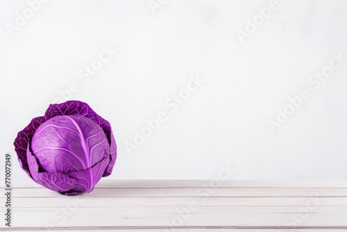 Fresh purple cabbage on a rustic wooden table over white background with copy space for text
