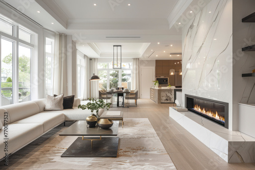 Contemporary living room with open concept view through to dining room kitchen and a marble fireplace with gas fire. photo