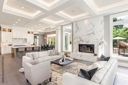 Contemporary living room with open concept view through to dining room kitchen and a marble fireplace with gas fire.