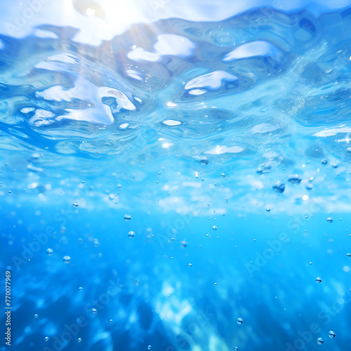 Underwater view of blue sea water surface with bubbles and sunlight.