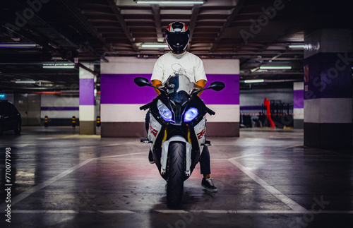 rider above his motorcycle in a underground garage at night 