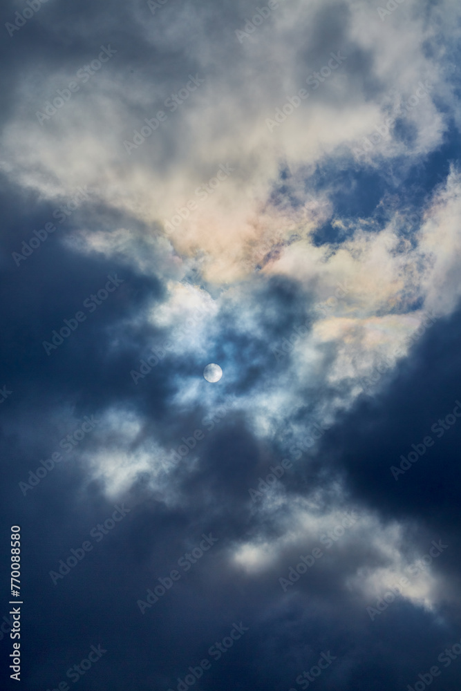 The moon in the night sky is visible through the clouds, clouds cover the moon in the night sky, moonlight through the clouds