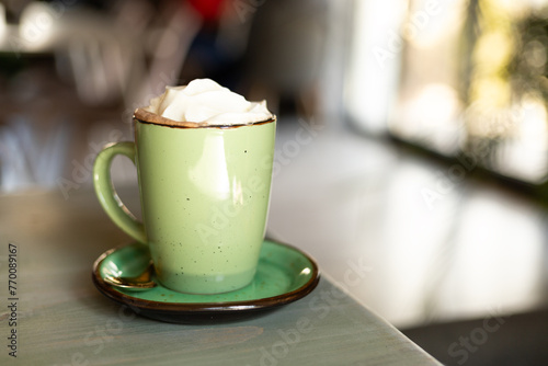 Tableau sur toile cocoa in a green cup with whipped cream