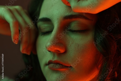 Fototapeta Naklejka Na Ścianę i Meble -  Portrait of beautiful young woman on color background with neon lights, closeup