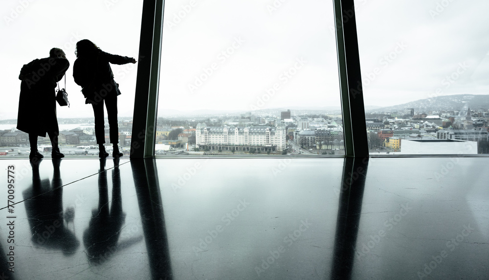 silhouettes of people in front of a glass facade