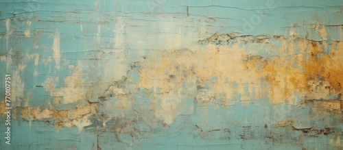 Peeling paint in shades of yellow and blue on a close-up of a wall's surface, revealing a weathered and textured appearance