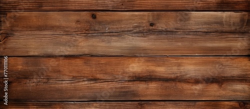 A close up of a brown hardwood plank flooring, showcasing a grainy texture with a varnish finish. The rectangle pattern creates a warm beige tone