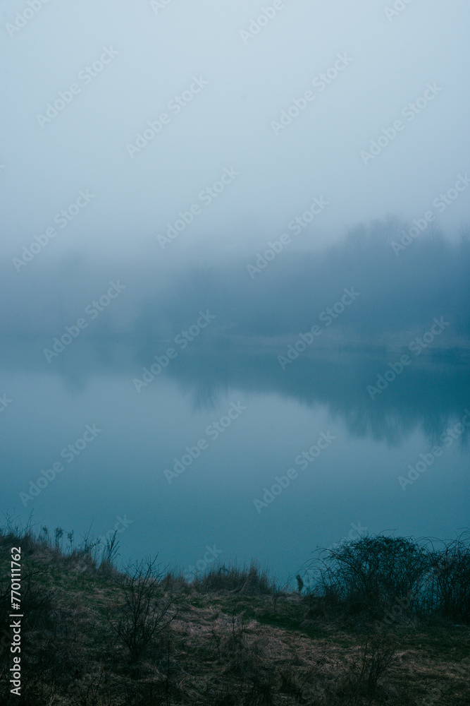 Foggy frost lake . Landscape with fog . Mystery nature . Blue hour . Morning at winter .