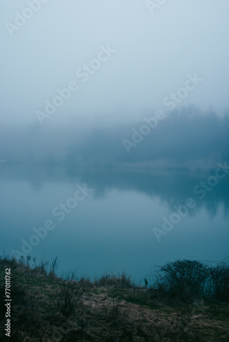 Foggy frost lake . Landscape with fog . Mystery nature . Blue hour . Morning at winter .