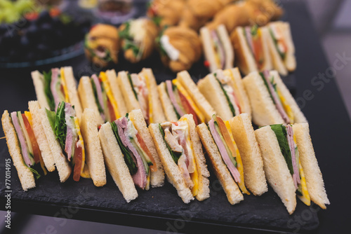 Catering table, beautifully decorated banquet table with variety of different food snacks, sandwiches, croissants and appetizers on party event or celebration, delicatessen setting, coffee break