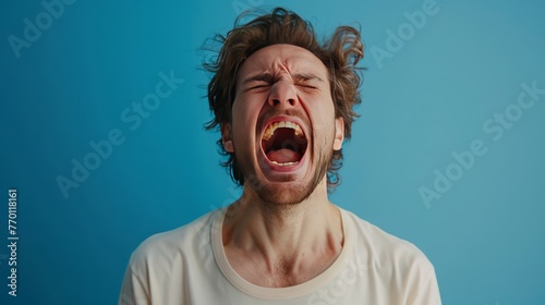 A man shouting loudly on isolated blue background
