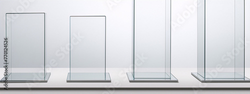 Four glass and metal display cases on white background, minimalist