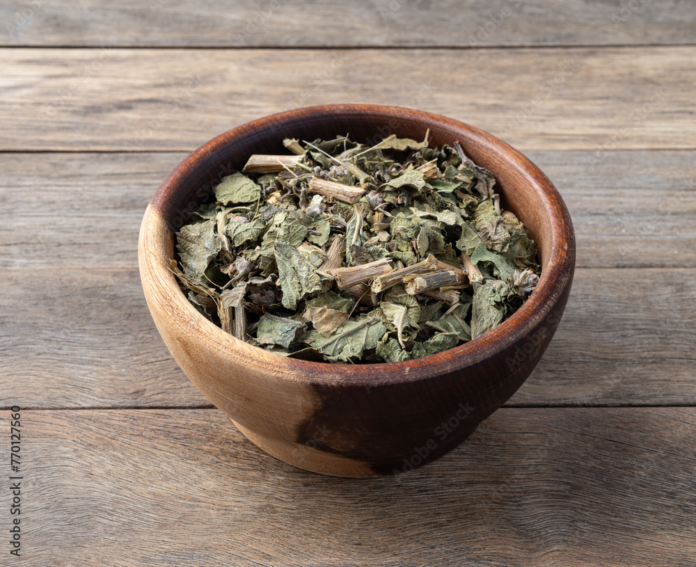 Lemon balm or Melissa dried tea leaves on a bowl over wooden table Lemon balm or Melissa dried tea leaves on a bowl over wooden table