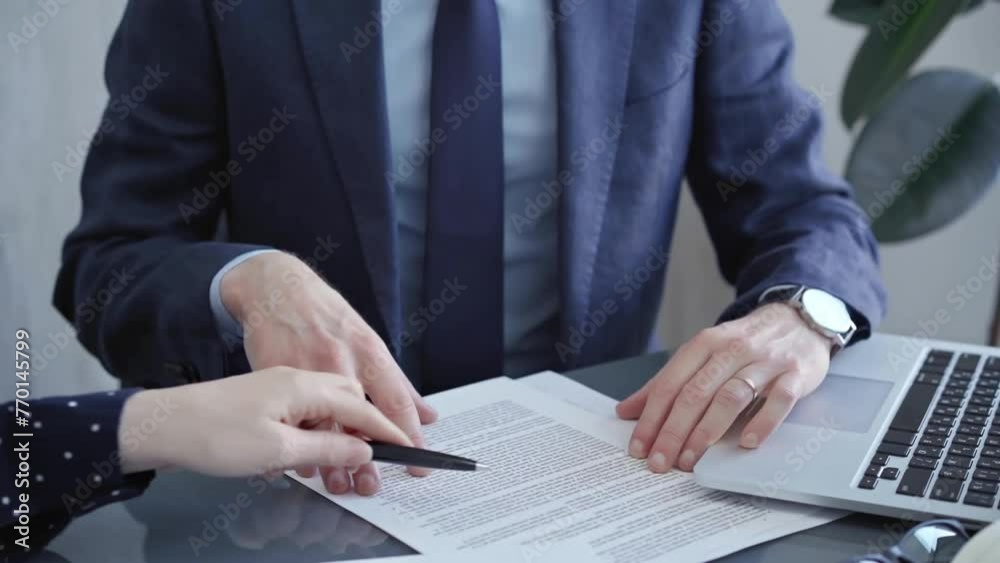 Business people or lawyers are discussing contract terms before signing. Close-up of a man and woman sitting at the desk in office background Business people or lawyers are discussing contract terms before signing. Close-up of a man and woman sitting at the desk in office background