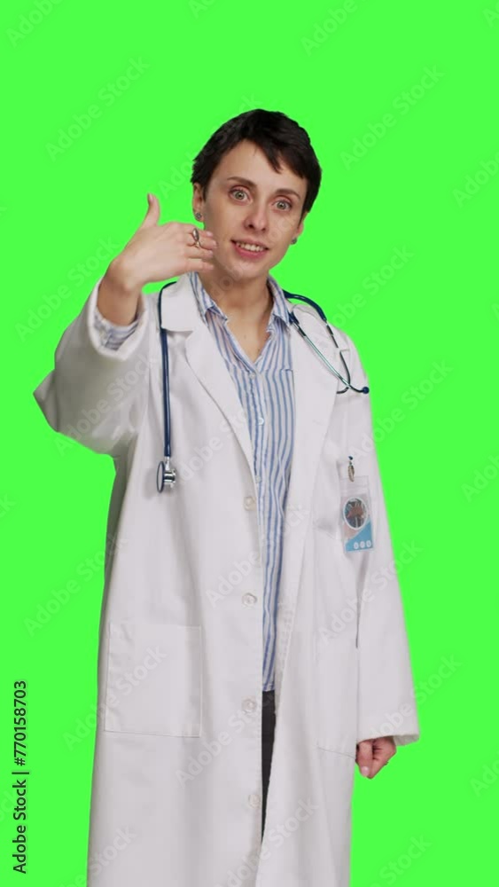 Front view Friendly physician inviting people to come closer to her against greenscreen backdrop, calling patients over and smiling. General practitioner asking persons to approach her. Camera B. Front view Friendly physician inviting people to come closer to her against greenscreen backdrop, calling patients over and smiling. General practitioner asking persons to approach her. Camera B.