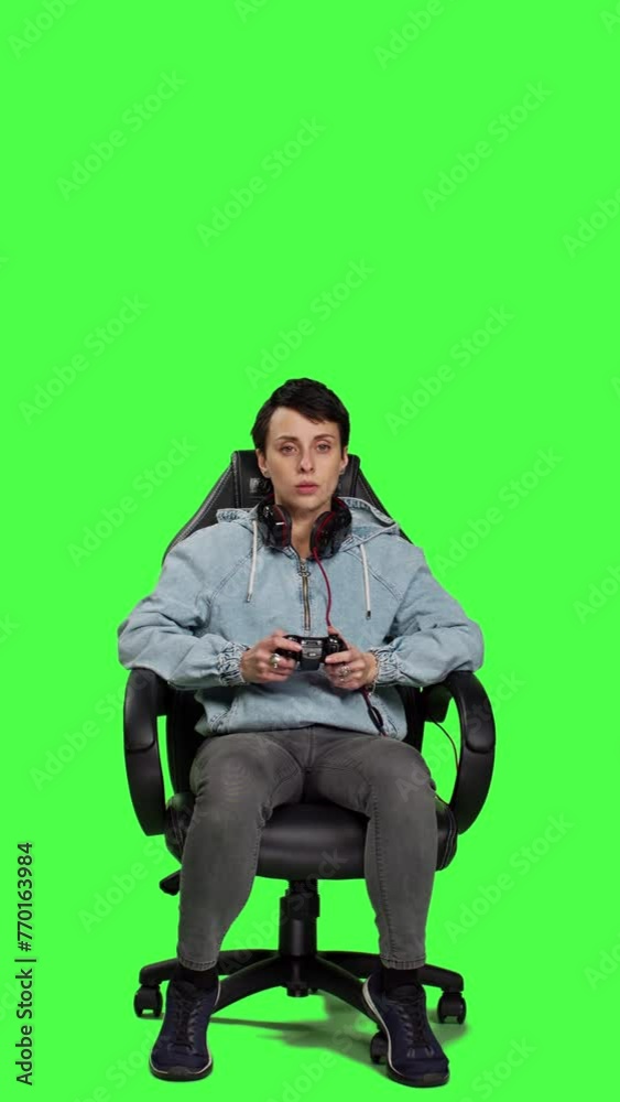 Front view Woman gamer playing online video games with controller, sitting in an office chair against greenscreen backdrop. Joyful person having fun with e sport competition, modern gaming setup Front view Woman gamer playing online video games with controller, sitting in an office chair against greenscreen backdrop. Joyful person having fun with e sport competition, modern gaming setup