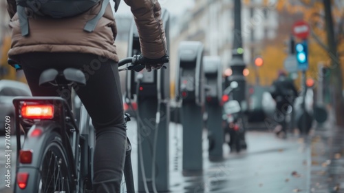 A cyclist pedals through a bustling city passing by rows of charging stations for electric bikes and scooters powered by renewable . .