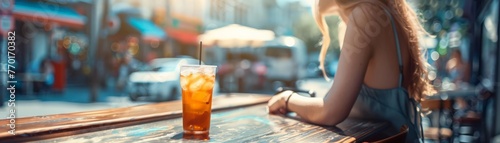 A woman sits at a bar with a drink in front of her